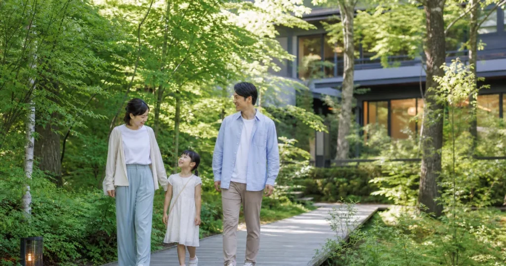 夏の軽井沢で森の中を歩く子連れ家族のイメージ画像
