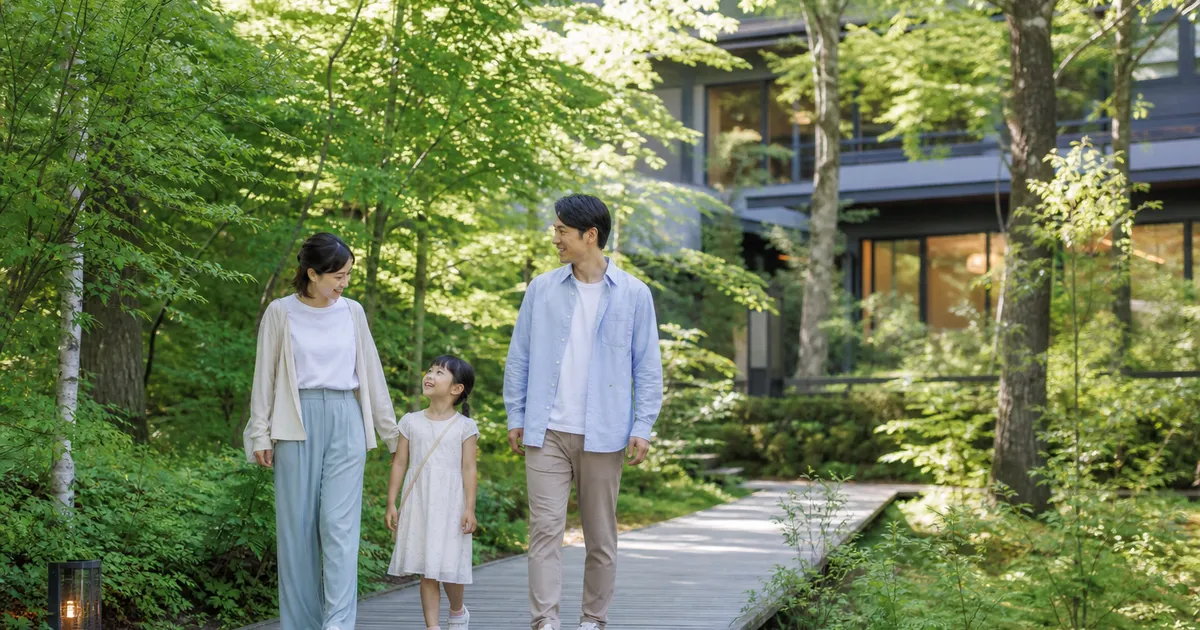 夏の軽井沢で森の中を歩く子連れ家族のイメージ画像